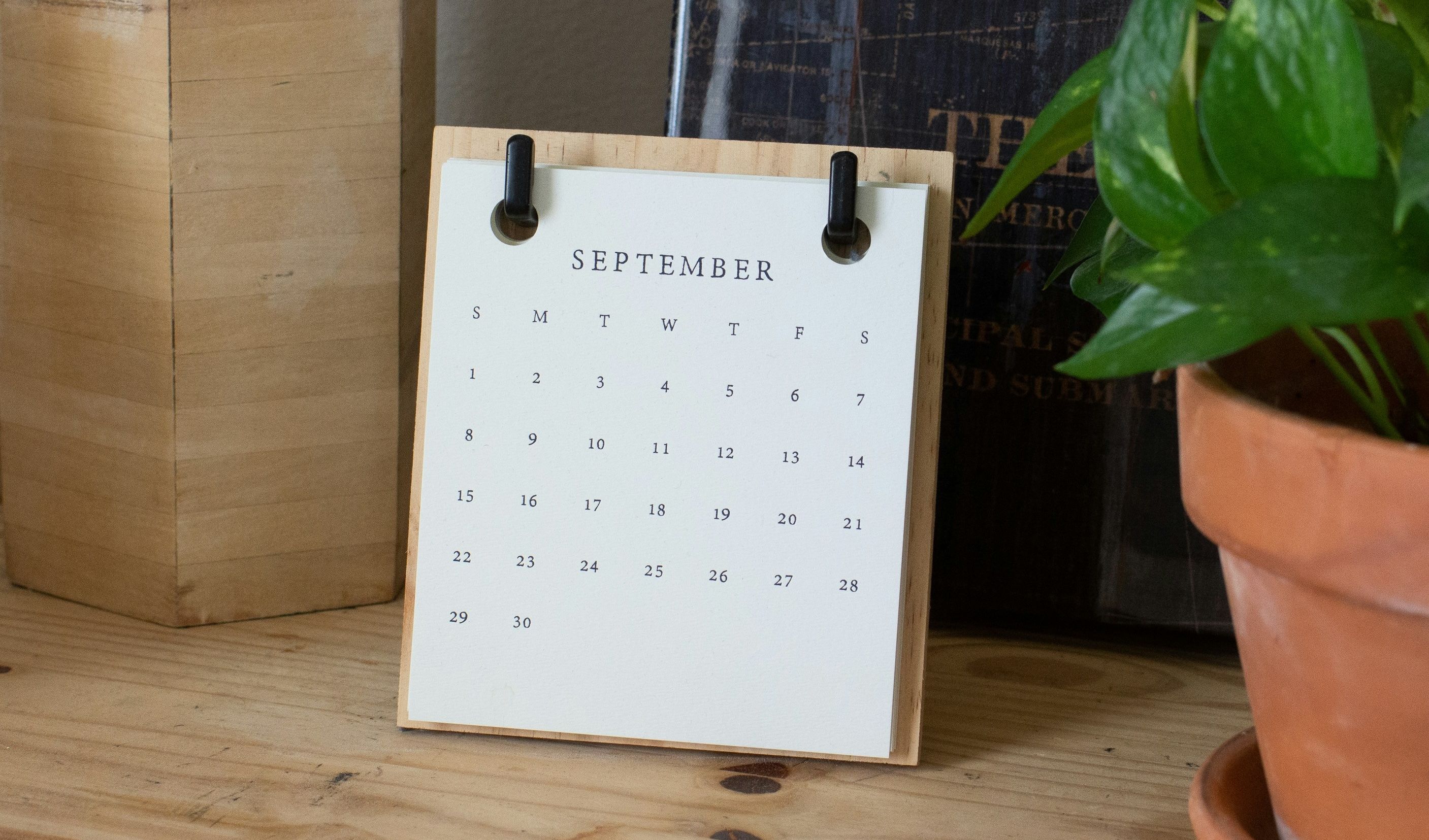 Dresser top with mini calendar of September and potted plant