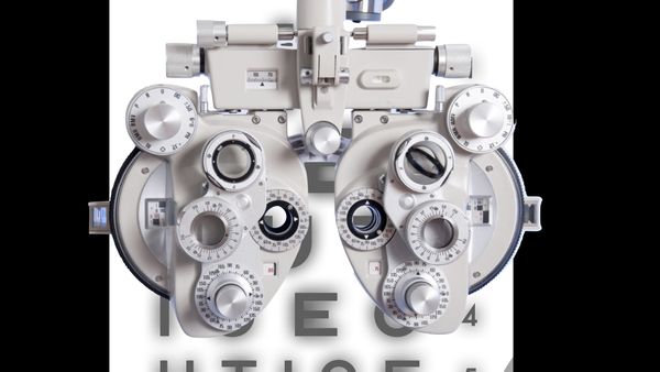 A phoropter sits in front of an eye chart