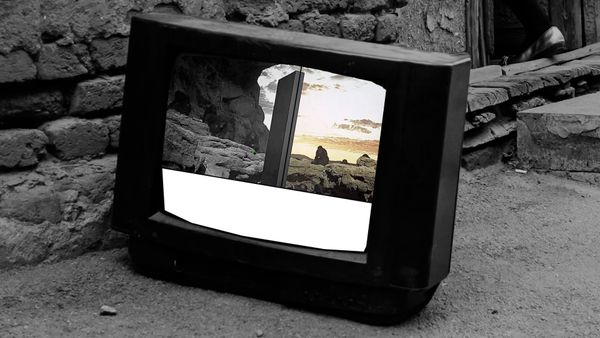 The television shows the comparison demo, black and white beside color